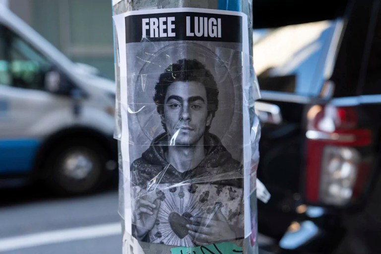A poster depicting Luigi Mangione hangs outside the New York Hilton Midtown hotel, Thursday, Dec. 12, 2024, in New York.