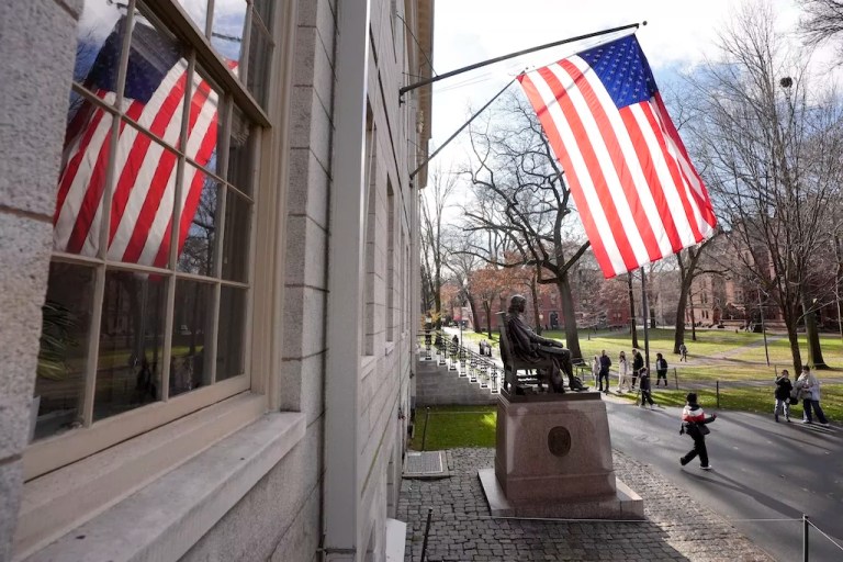 People walk past the John Harvard statue in Harvard Yard, Tuesday, Dec. 17, 2024, on the campus of Harvard University in Cambridge, Mass.