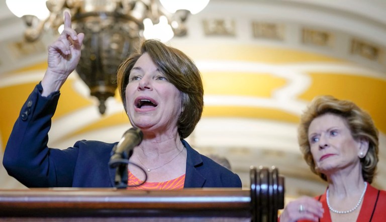 Sen. Amy Klobuchar (D-MN) speaks as Sen. Debbie Stabenow (D-MI), right, listens during a news conference after a policy luncheon, Wednesday, May 31, 2023, on Capitol Hill in Washington.