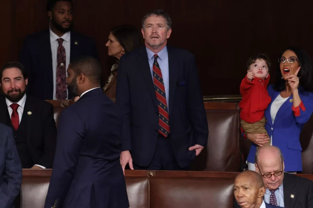 Rep. Thomas Massie (R-KY) stands in the House chamber on Jan. 3, 2025, on the first day of the 119th Congress. To his right, Rep. Lauren Boebert (R-CO) holds her grandchild Tyler.