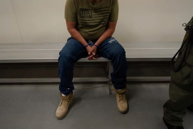 An immigrant considered a threat to public safety and national security threat waits to be processed by Immigration and Customs Enforcement agents at the ICE Metropolitan Detention Center in Los Angeles after an early morning raid, June 6, 2022.