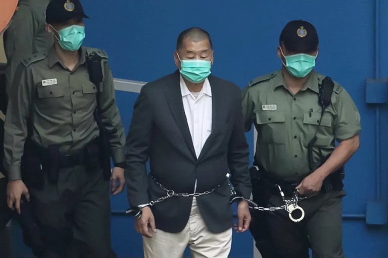 Jimmy Lai is escorted by Correctional Services officers to get on a prison van on Dec. 12, 2020, before appearing in a court in Hong Kong.
