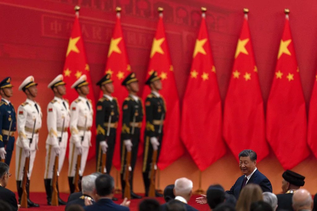 Chinese President Xi Jinping, right, invites winners of the national medals to join him after a ceremony held in the Great Hall of the People in Beijing, Sunday, Sept. 29, 2024. 