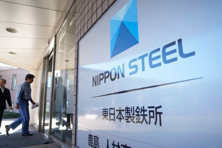 A staff member enters a doorway next to the Nippon Steel logo on Friday, Dec. 6, 2024, at the company's Kashima Plant in Kashima, Japan. (AP Photo/Ayaka McGill)