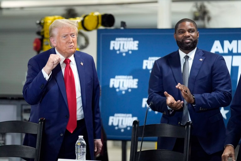 Former President Donald Trump, Republican presidential nominee, arrives for a roundtable, Friday, Oct. 18, 2024, in Auburn Hills, Michigan, as Rep. Byron Donalds (R-FL) watches.