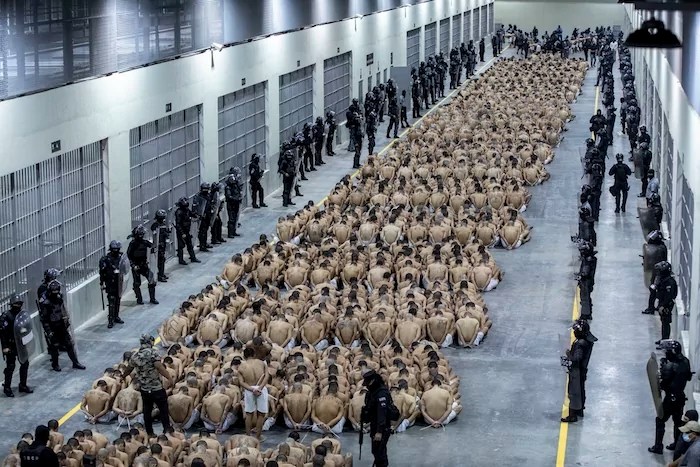 Inmates identified by authorities as gang members are seated on the prison floor of the Terrorism Confinement Center in Tecoluca, El Salvador, March 15, 2023.