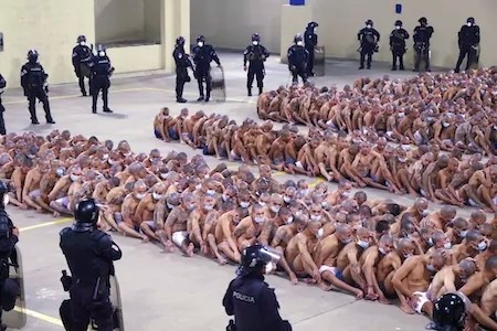 Police officers guard inmates during a security operation at the Izalco prison in San Salvador, El Salvador, Saturday, April 25, 2020.