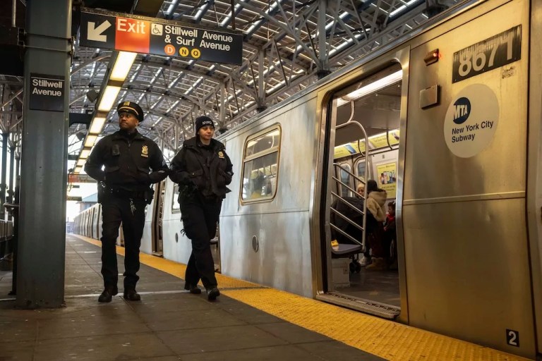 Police officers patrol the F train platform at the Coney Island-Stillwell Avenue Station, Thursday, Dec. 26, 2024, in New York.