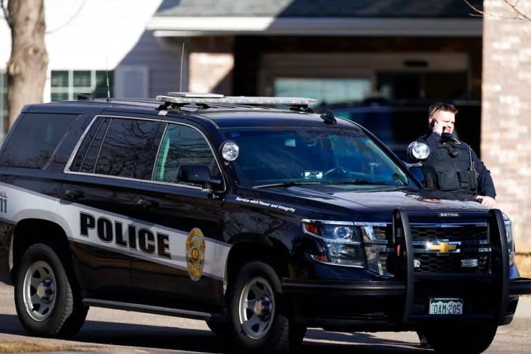 A police officer talks on a mobile device outside the Legacy Assisted Living at Lafayette care facility, Wednesday, Feb. 3, 2021, in Lafayette, Colorado. A 95-year-old resident of the assisted care home was taken into police custody Wednesday after allegedly shooting an employee at the center.