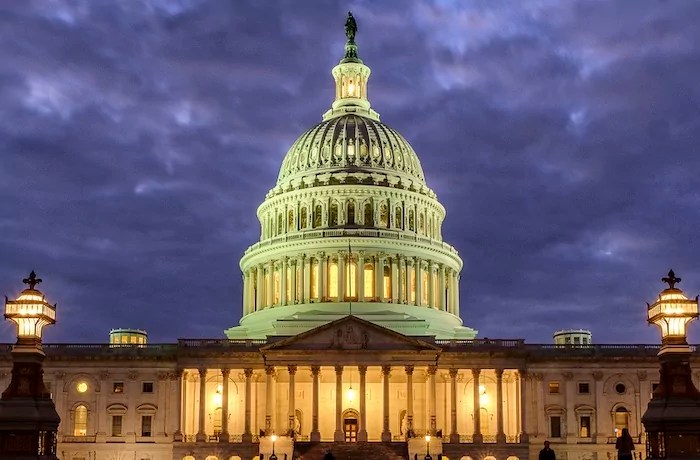 Lights shine inside the Capitol Building as night falls, Jan. 21, 2018, in Washington.