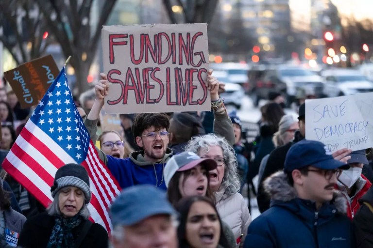 People protest against a funding freeze of federal grants and loans following a push from President Donald Trump to pause federal funding near to the White House in Washington, Tuesday, Jan. 28, 2025.