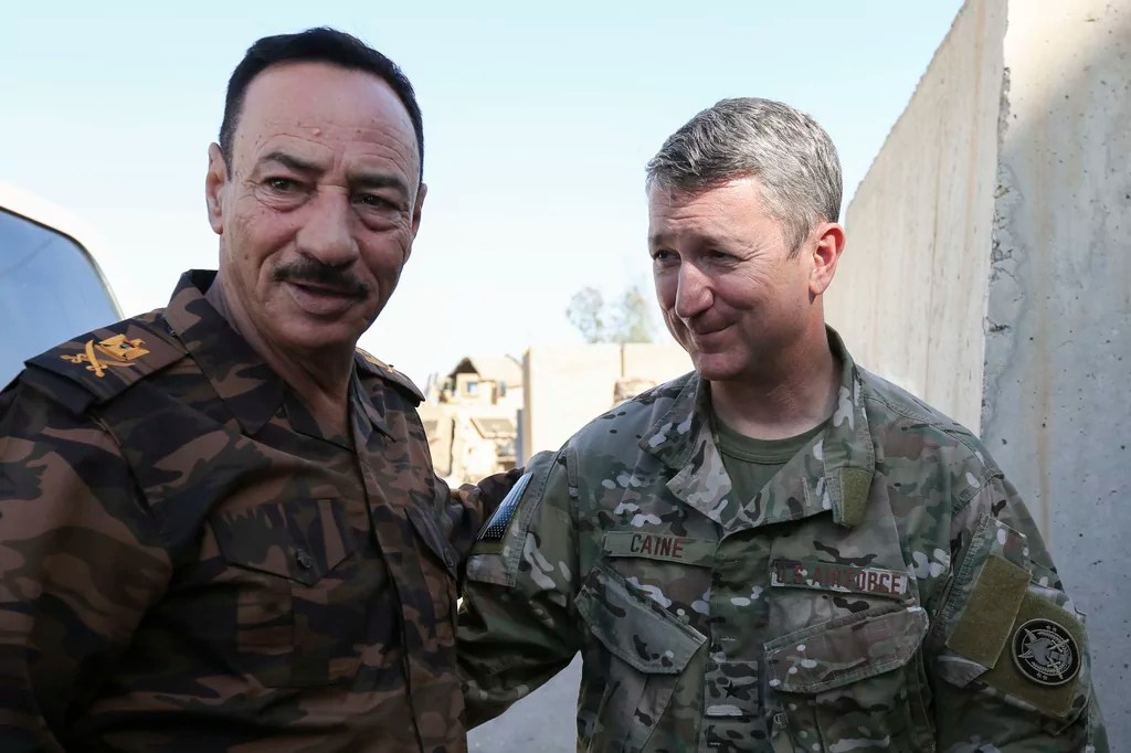 This image provided the U.S. Army shows, Air Force Brig. Gen. Daniel Caine, right, meeting with Ninewa Operational Center Commander, Major Gen. Najim, in Mosul, Iraq, June 26, 2018. 