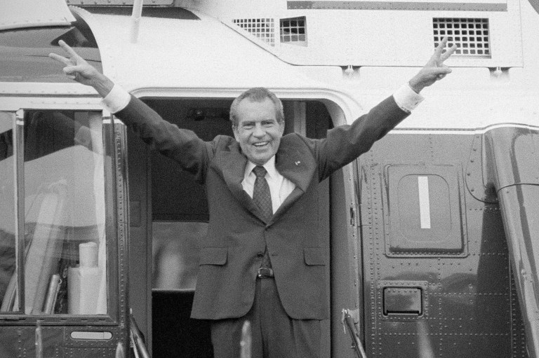 Richard Nixon says goodbye with a victorious salute to his staff members outside the White House as he boards a helicopter after resigning the presidency, Aug. 9, 1974.