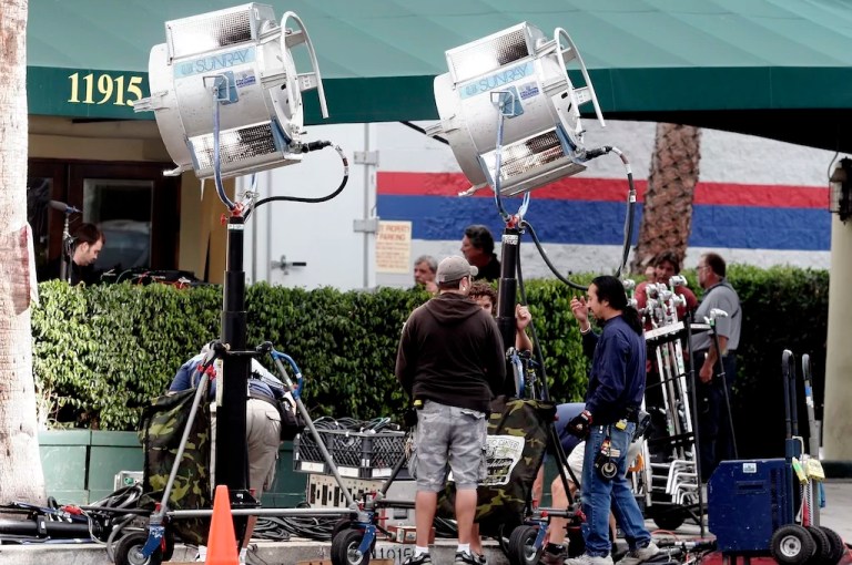 Production crew members work on a film set along Ventura Blvd., near to CBS Studios in the Studio City section of Los Angeles.