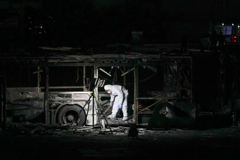 An Israeli police officer inspects the scene of one of a series of bus explosions in what authorities said appeared to be an attack in Bat Yam, central Israel.