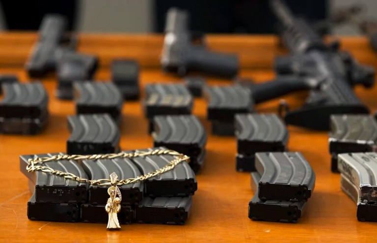 A Santa Muerte or Grim Reaper pendant is displayed next to guns and ammunition magazines seized by the Mexican Army during a presentation of suspected gunmen and kidnappers to the press in Tijuana, Mexico, Tuesday, Dec. 2, 2008. According to Mexican army authorities, the suspects could have been involved in three days of violence that left 37 people dead in this border city plagued by warring drug gangs, including nine men found decapitated and four children caught in the middle of shoot-outs.