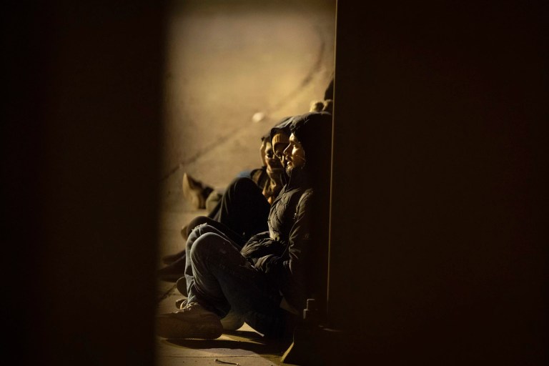 A group of migrants wait to be processed between border walls separating Mexico and the United States after crossing illegally before dawn Tuesday, Jan. 21, 2025, in San Diego.