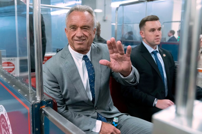 Robert F. Kennedy Jr. waves to reporters as he rides the train to go meet with Sen. John Thune (R-SD) at the Capitol in Washington, Dec. 17, 2024.