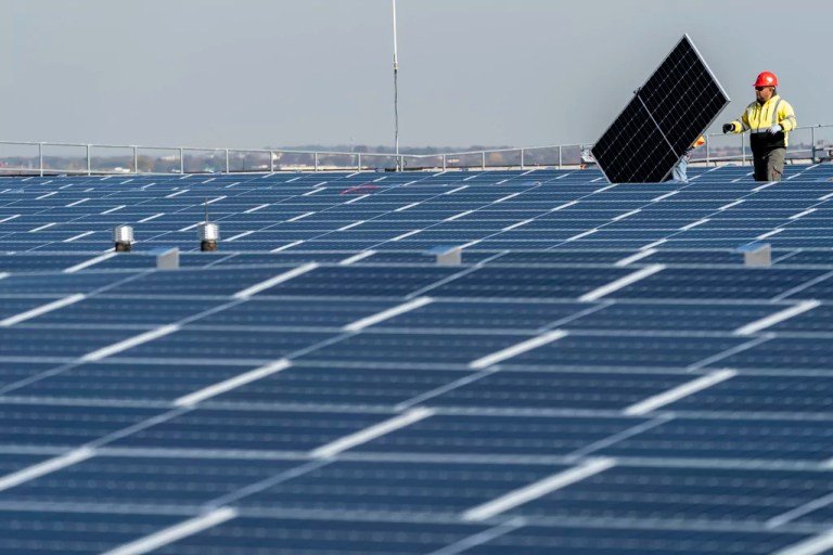 Electricians with IBEW Local 3 install solar panels on top of the Terminal B garage at LaGuardia Airport, Nov. 9, 2021, in the Queens borough of New York.