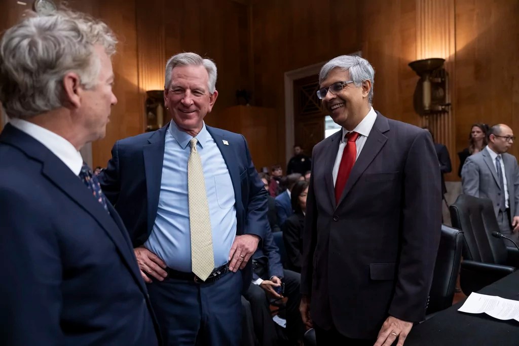 Dr. Jay Bhattacharya, President Donald Trump's choice to be Director of the National Institutes of Health, right, speaks with Sen. Tommy Tuberville, R-Ala., center, and Sen. Rand Paul, R-Ky., left, before appearing before the Senate Health, Education, Labor, and Pensions Committee for his confirmation hearing, at Capitol Hill in Washington, Wednesday, March 5, 2025. 