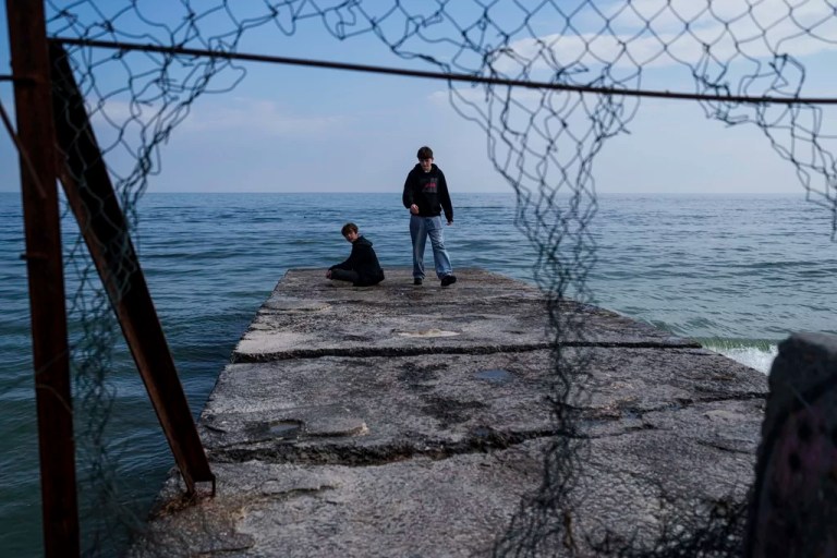 Students are seen on a breakwater at the Lanzheron beach in Odesa, Ukraine, March 26, 2025.