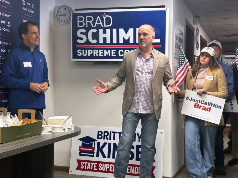 Wisconsin Supreme Court candidate Brad Schimel, center, speaks with supporters as former Gov. Scott Walker, left, watches on Monday, March 31, 2025, in Madison, Wis.