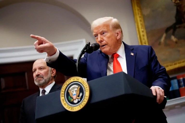 President Donald Trump, accompanied by Commerce Secretary Howard Lutnick, left, takes a question from a reporter in the Roosevelt Room of the White House on March 3, 2025 in Washington, D.C.