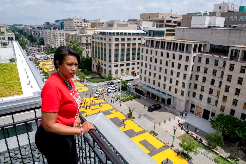 In this image provided by the Executive Office of the Mayor, District of Columbia Mayor Muriel Bowser stands on the rooftop of the Hay Adams Hotel near the White House and looks out at the words 'Black Lives Matter' that have been painted in bright yellow letters on the street by city workers and activists, Friday, June 5, 2020, in Washington.