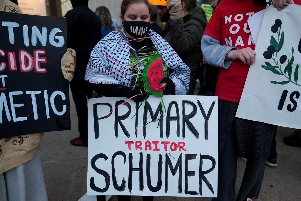 Demonstrators gather in front of the Central Library branch of the Enoch Pratt Free Library in Baltimore after Senate Democratic Leader Chuck Schumer's scheduled book tour event was postponed, Monday, March 17, 2025. (AP Photo/Stephanie Scarbrough)