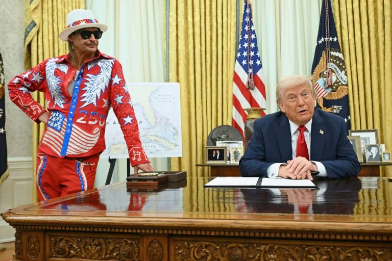 President Donald Trump speaks to reporters before signing an executive order in the Oval Office of the White House in Washington, Monday, March 31, 2025, as Kid Rock listens. (Pool via AP)