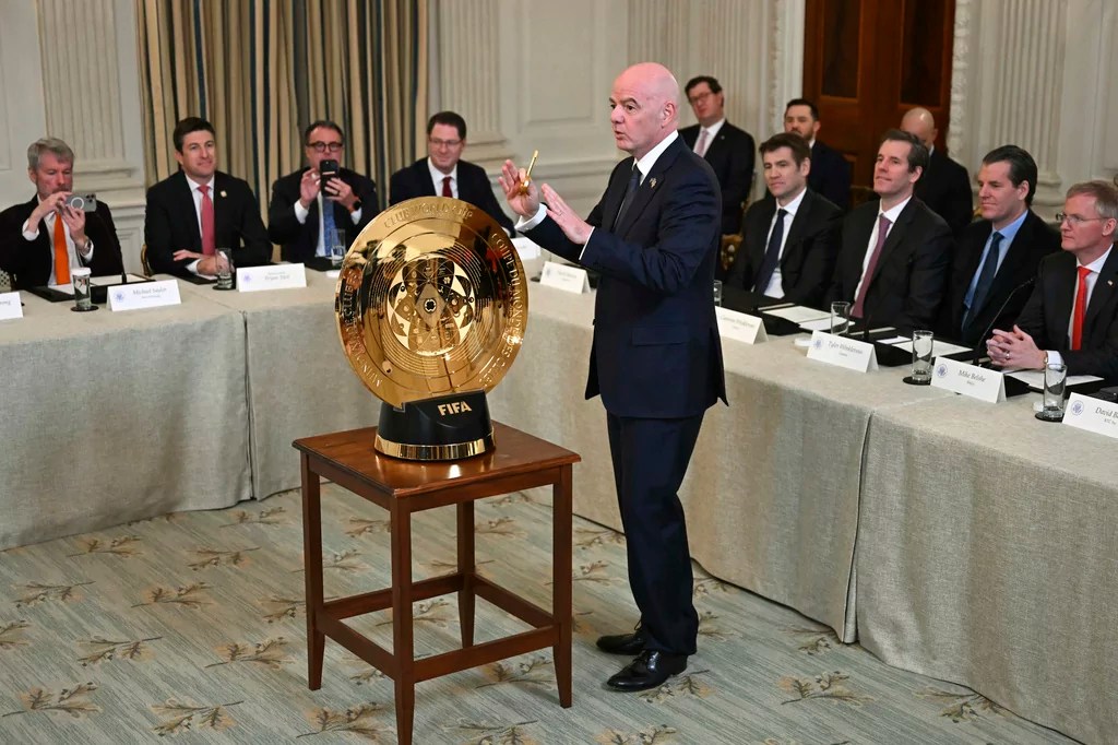 FIFA president Gianni Infantino unlocks the new FIFA Club World Cup trophy during the White House Crypto Summit in Washington, Friday, March 7, 2025. (Pool via AP)