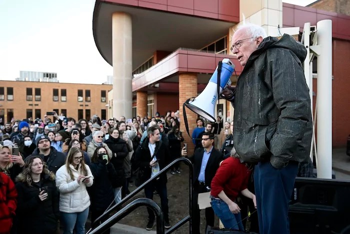 Sen. Bernie Sanders (I-VT), right, speaks to an overflow crowd outside Lincoln High School as he talks about 