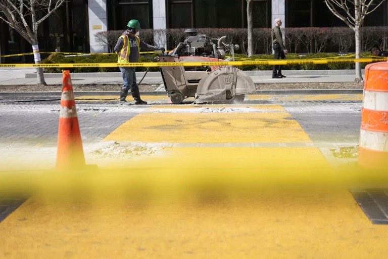 Workers remove stones from the road as demolition continues on the Black Lives Matter mural, Wednesday, March 12, 2025, in Washington.