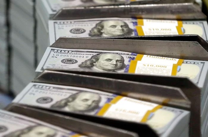 In this photo taken Sept. 24, 2013, just cut stacks of $100 bills make their way down the line at the Bureau of Engraving and Printing