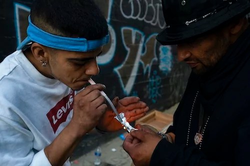 Two homeless addicts share a small piece of fentanyl in an alley in Los Angeles.