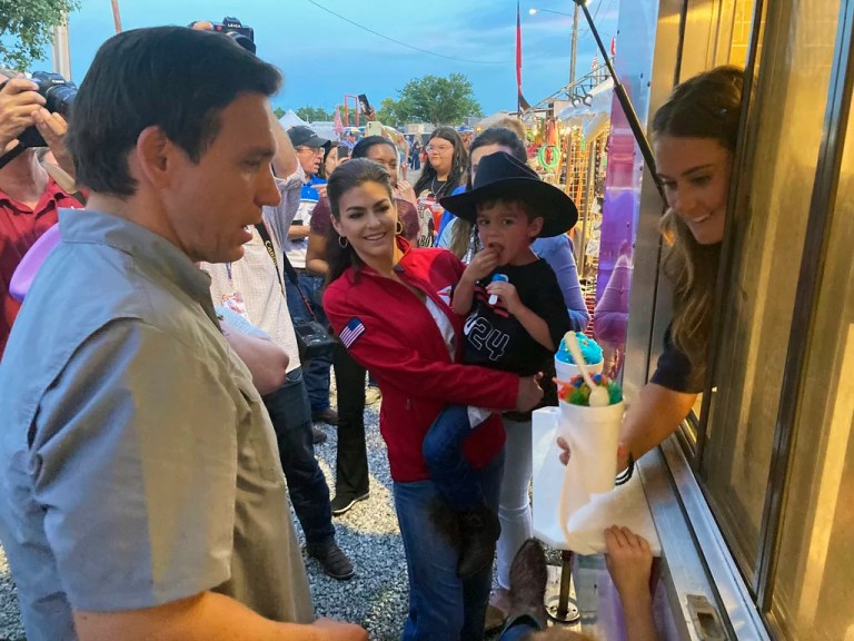 Casey DeSantis, center, and son Mason watch as husband and father, Republican presidential candidate and Florida Gov. Ron DeSantis orders snow cones for the family, at the rodeo, in Ponca, Okla., Saturday, June 10, 2023.