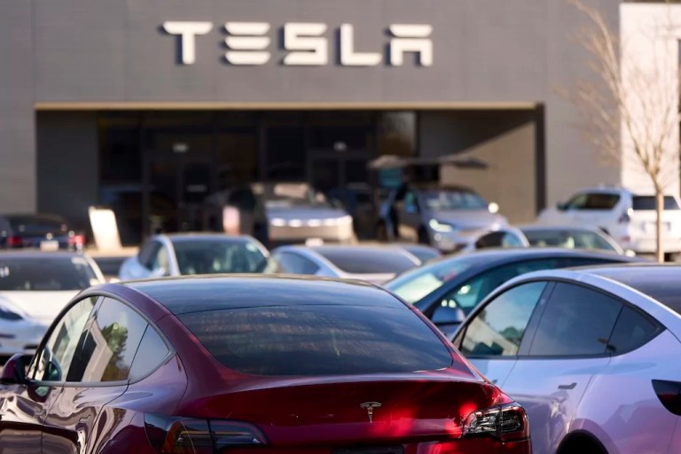 A Tesla Model Y and other Telsla vehicles sit at a dealership, Wednesday, March 19, 2025, in Kennesaw, Georgia.