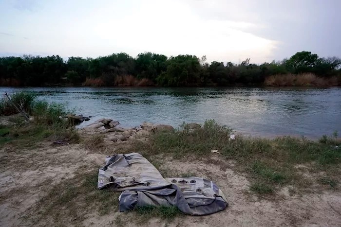 A deflated raft sits along the U.S.-Mexico border Tuesday, May 11, 2021, in Roma, Texas. The U.S. government continues to report large numbers of migrants crossing the U.S.-Mexico border with an increase in adult crossers. But families and unaccompanied children are still arriving in dramatic numbers despite the weather changing in the Rio Grande Valley registering hotter days and nights. (AP Photo/Gregory Bull)
