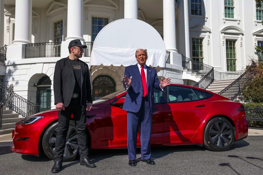 President Donald Trump and Tesla CEO Elon Musk speak to reporters in front of a red Model S Tesla vehicle on the South Lawn of the White House Tuesday, March 11, 2025, in Washington.