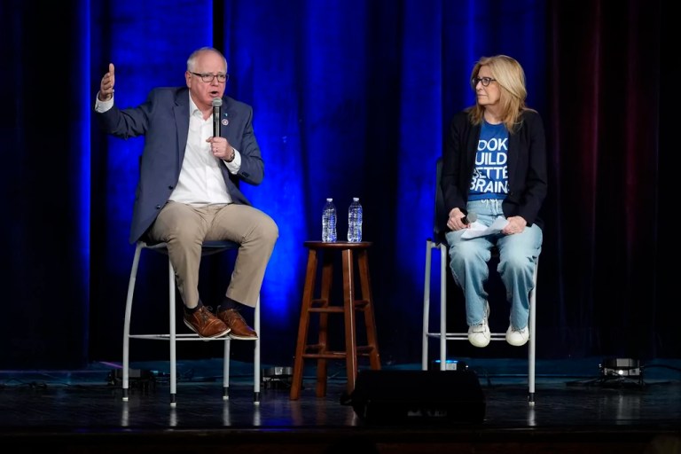 Gov. Tim Walz (D-MN), left, and Rita Hart, chairwoman of the Iowa Democratic Party, speak at a town hall event at Roosevelt High School, Friday, March 14, 2025, in Des Moines, Iowa.