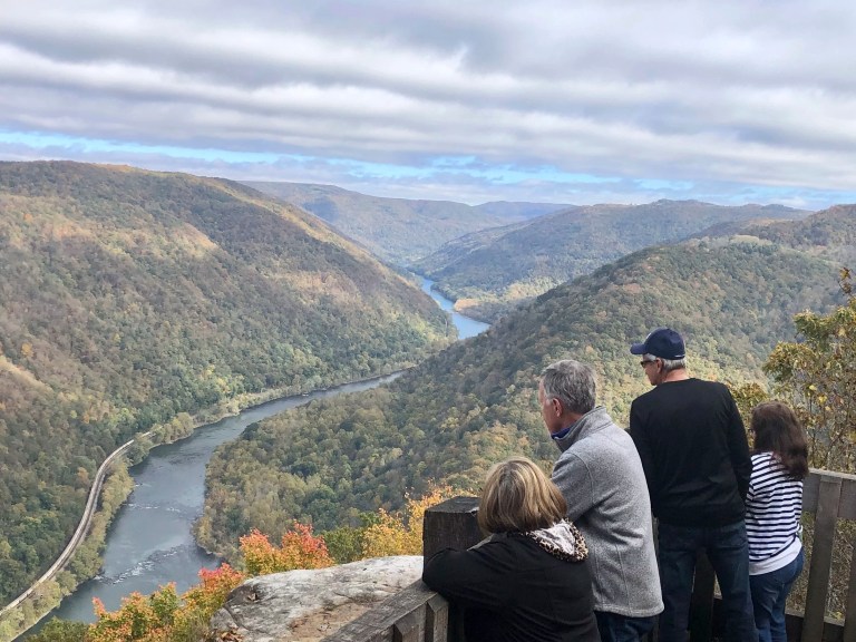Visitors look down on the New River Gorge from a national park overlook Wednesday, Oct. 27, 2021, in Grandview, West Virginia. Under legislation passed by Congress in 2020, some of America's most spectacular natural settings are getting a makeover. Historic masonry grills have been restored near the Grandview Visitor Center.