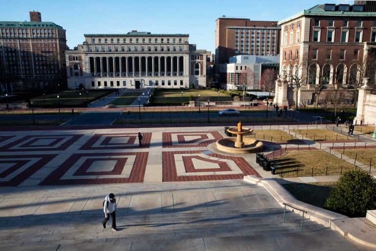 A woman walks on the Columbia University campus, Monday, March 9, 2020, in New York. U.S. News & World Report has unranked Columbia University from its 2022 edition of Best Colleges. The publisher said in a statement Thursday, July 7, 2022, that the Ivy League institution failed to substantiate certain 2021 data it previously submitted, including student-faculty ratios and class size.