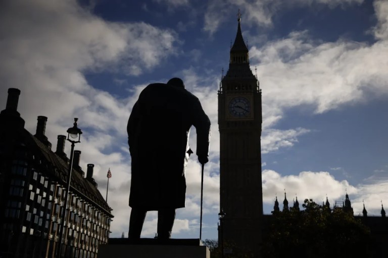 The statue of wartime prime minister Winston Churchill is seen next to the Big Ben tower of Houses of Parliament, right, at sunrise in London, Monday, Oct. 24, 2022.