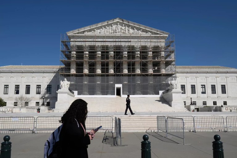 A person walks past as construction scaffolding is in place at the Supreme Court Tuesday, April 1, 2025, in Washington.