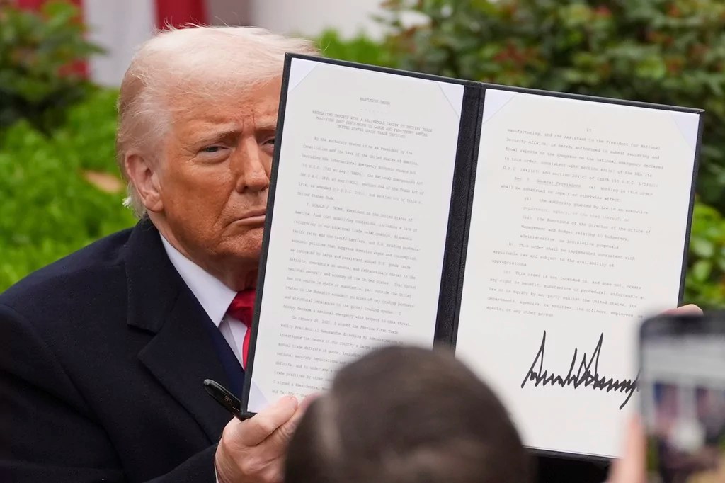 President Donald Trump holds a signed executive order during an event to announce new tariffs in the Rose Garden of the White House, Wednesday, April 2, 2025, in Washington