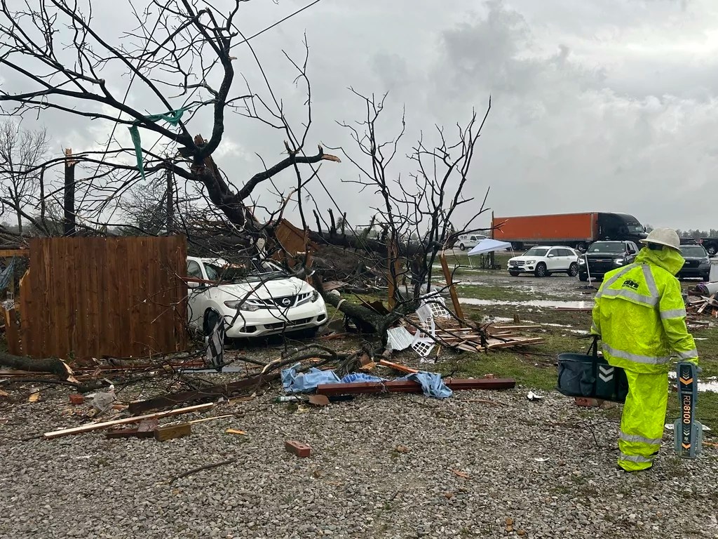 People look over the debris around a home at Lake City, Ark., on Thursday, April 3, 2025.