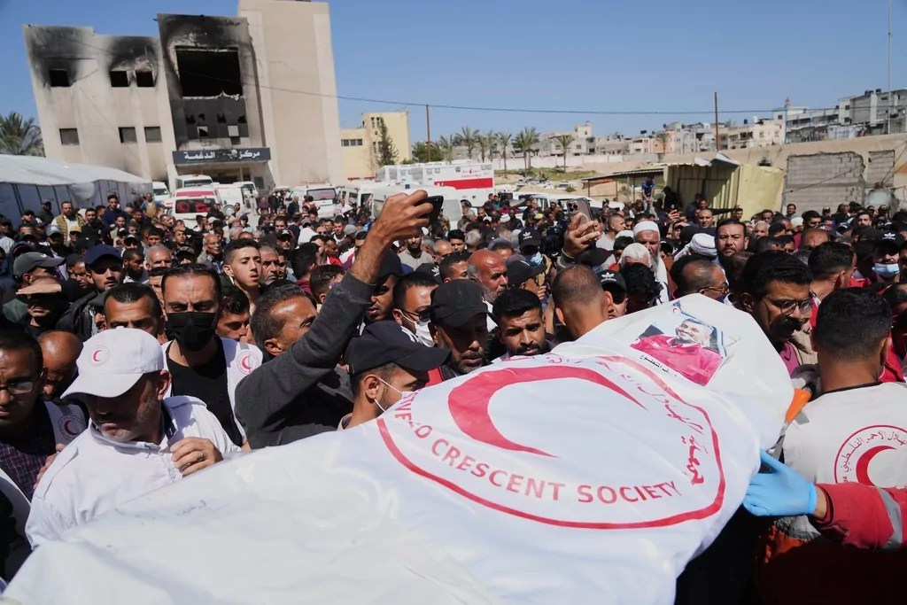 Mourners carry the bodies of 8 Red Crescent emergency responders, recovered in Rafah a week after an Israeli attack, as they are transported for burial from a hospital in Deir al-Balah, Gaza Strip, on Monday, March 31, 2025.