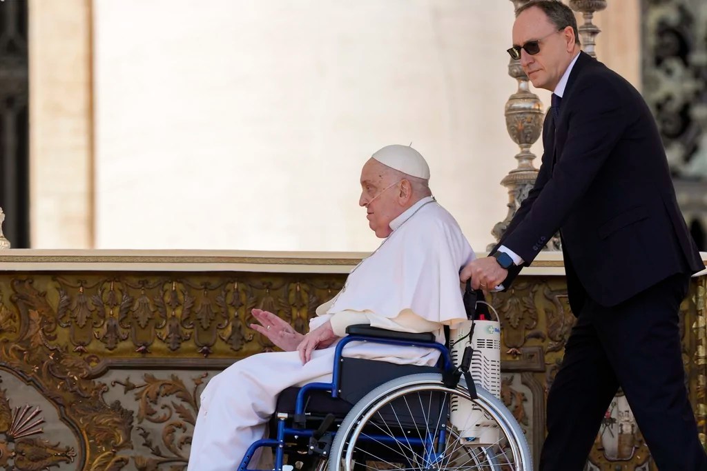 Pope Francis arrives in a wheelchair, helped by his Personal nurse Massimiliano Streppetti, at the end of a mass in St. Peter's Square at The Vatican