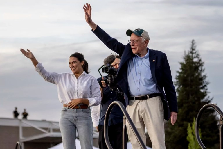 Rep. Alexandria Ocasio-Cortez (D-NY), left, and Sen. Bernie Sanders (I-VT) wave during a stop of the 'Fighting Oligarchy' rally at Folsom Lake College in Folsom, Calif., Tuesday, April 15, 2025.
