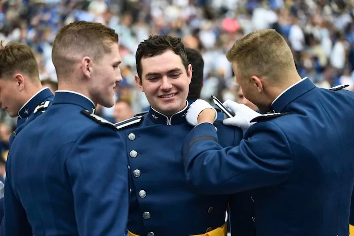 A Cadet gets help with his shoulder boards after graduation ceremonies during the U.S. Air Force Academy graduation ceremony Thursday, June 1, 2023, at Air force Academy, Colorado.